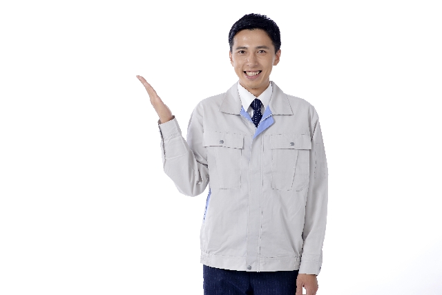 手を上げている作業服の男性